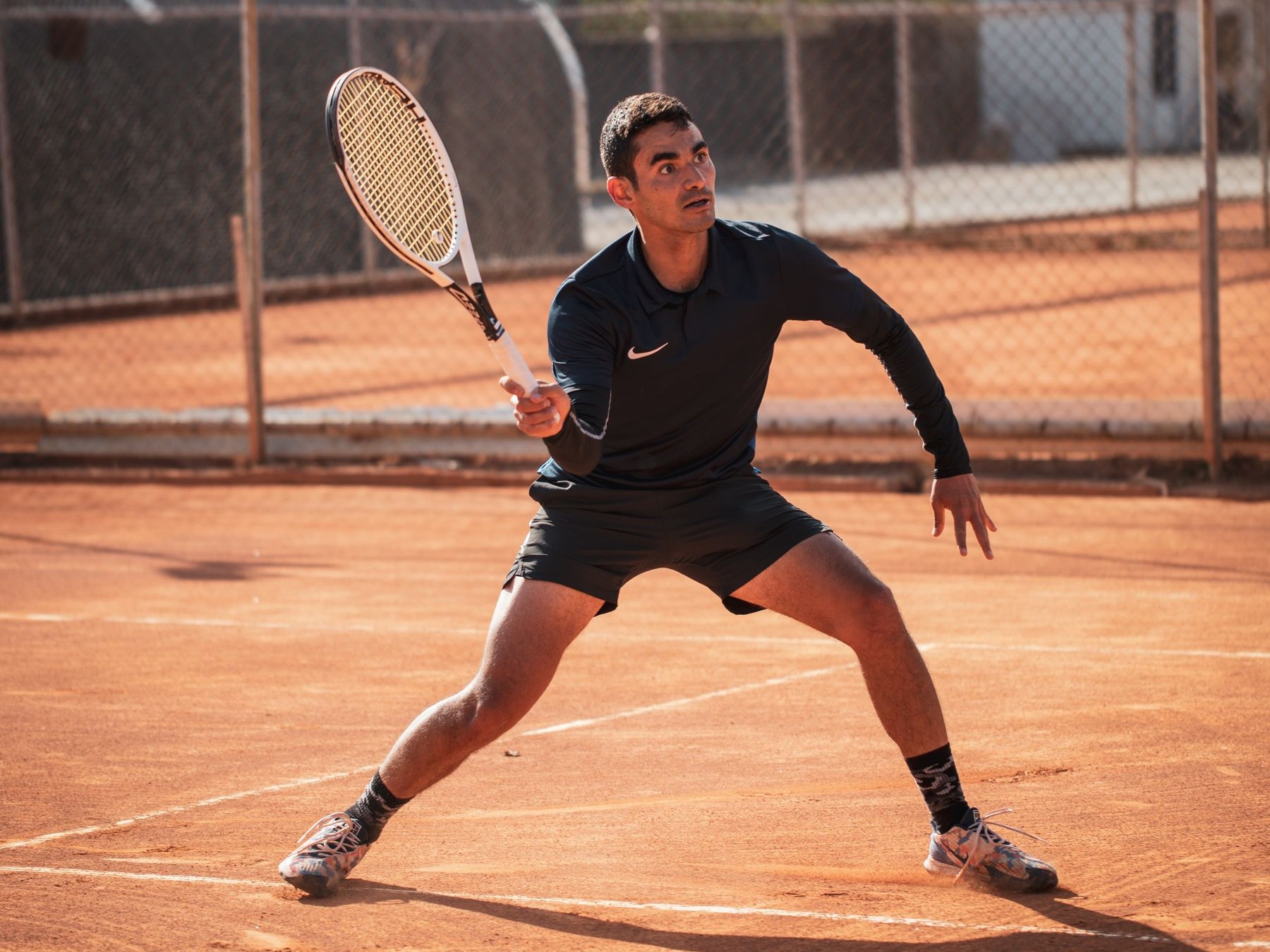 Adult tennis player performing a lateral court movement during tennis fitness training.